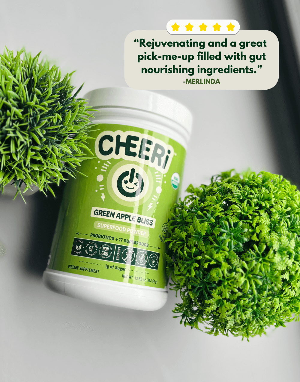 CHEERi Green Apple Bliss Elixir with green plants, highlighting gut health and revitalizing benefits.